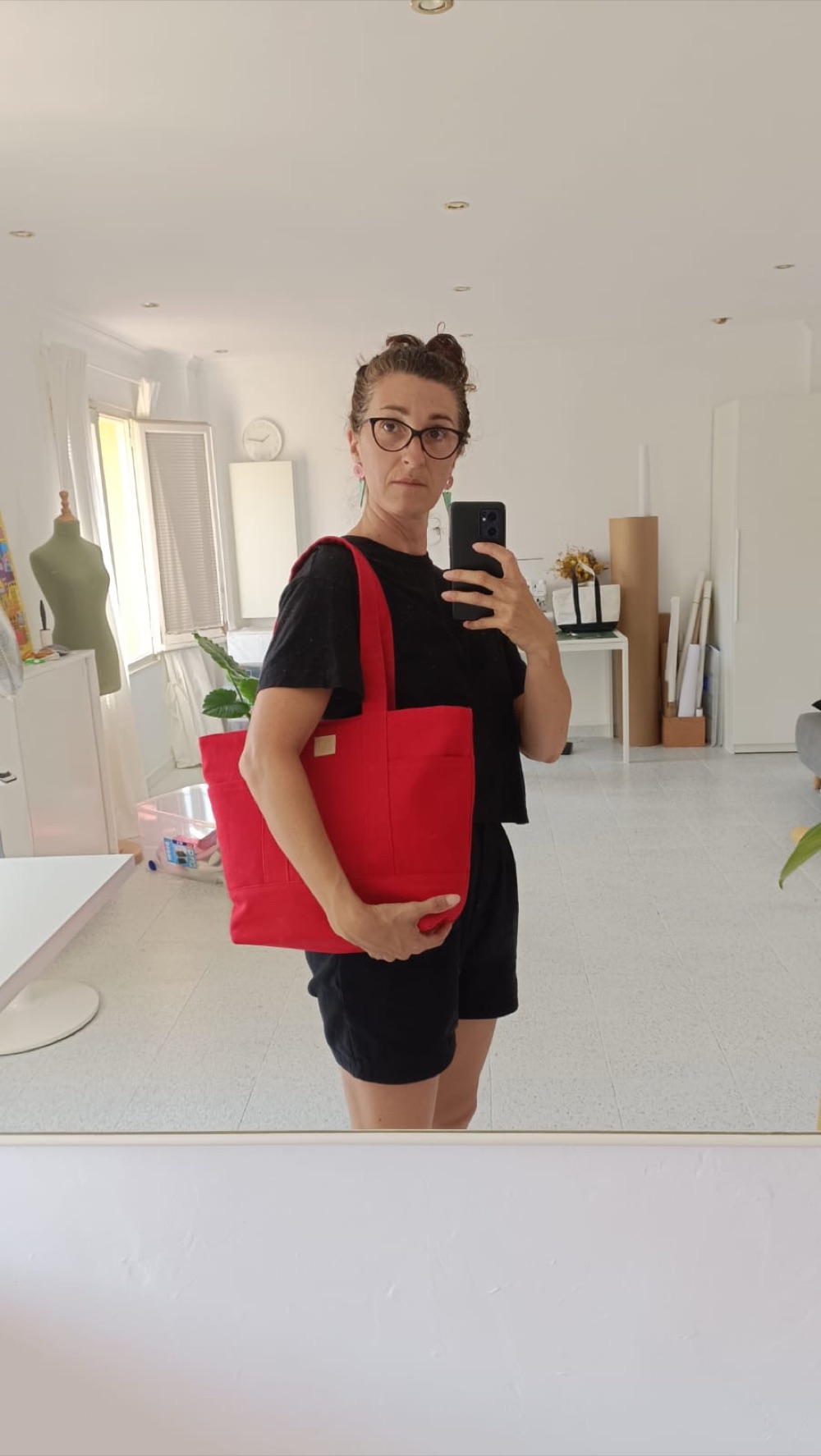La Juli, creadora de JUL Positive Design, al seu taller amb una bossa Barcelona Medium vermella a l'espatlla